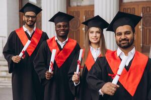 Diverse Group of Happy Graduates in Caps and Gowns Celebrating Success in Front of University Building photo