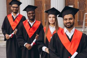 Diverse Group of Happy Graduates in Caps and Gowns Celebrating Success in Front of University Building photo