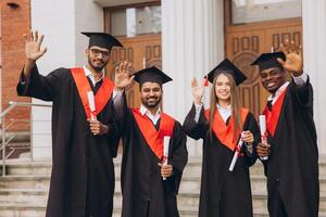 Diverse Group of Happy Graduates Celebrating Outside in Caps and Gowns with Diplomas photo