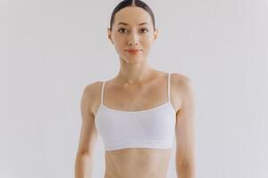 Portrait of beautiful woman with slim body in underwear posing in the white studio background with copy space, mock-up photo