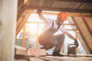 Process of construction new and modern modular house. Worker man in special protective uniform unrolls the carrier on building development industry of energy efficient property. photo