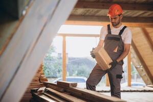 Process of construction new and modern modular house. Worker man in special protective uniform wear working on building development industry of energy efficient property. photo