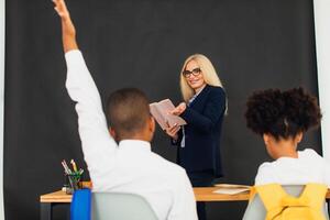 A girl and a boy, African-American school children, solve problems with the teacher during a lesson. Back to school. photo