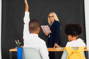 A girl and a boy, African-American school children, solve problems with the teacher during a lesson. Back to school. photo