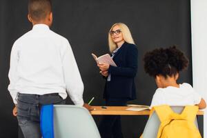 A girl and a boy, African-American school children, solve problems with the teacher during a lesson. Back to school. photo