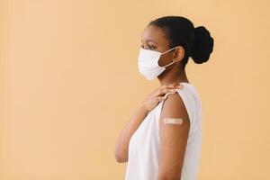 Smiling Multiethnic Patients In Medical Face Mask Showing Vaccinated Arm After Antiviral Injection For Covid-19 Protection, Posing On Studio Background, Looking At Camera photo
