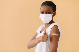 Smiling Multiethnic Patients In Medical Face Mask Showing Vaccinated Arm After Antiviral Injection For Covid-19 Protection, Posing On Studio Background, Looking At Camera photo