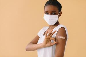 Smiling Multiethnic Patients In Medical Face Mask Showing Vaccinated Arm After Antiviral Injection For Covid-19 Protection, Posing On Studio Background, Looking At Camera photo
