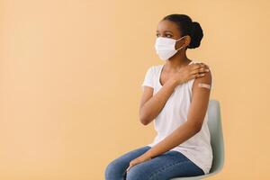 Smiling Multiethnic Patients In Medical Face Mask Showing Vaccinated Arm After Antiviral Injection For Covid-19 Protection, Posing On Studio Background, Looking At Camera photo