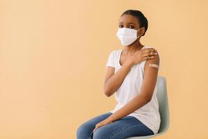 Smiling Multiethnic Patients In Medical Face Mask Showing Vaccinated Arm After Antiviral Injection For Covid-19 Protection, Posing On Studio Background, Looking At Camera photo