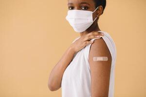 Smiling Multiethnic Patients In Medical Face Mask Showing Vaccinated Arm After Antiviral Injection For Covid-19 Protection, Posing On Studio Background, Looking At Camera photo