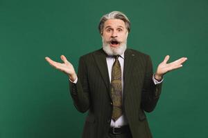 Bearded middle-aged man in khaki suit waving his hands to the side on a green background with copy space. photo