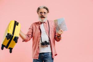 Happy bearded man in sunglasses holds a suitcase and a map, sings and dances photo