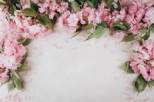 Sprigs of the sakura tree with flowers and petals on trendy marble background. Place for text. The concept of spring came. Top view. Flat lay photo