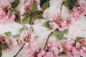 Sprigs of the sakura tree with flowers and petals on trendy marble background. Place for text. The concept of spring came. Top view. Flat lay photo