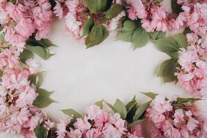 Sprigs of the sakura tree with flowers and petals on trendy marble background. Place for text. The concept of spring came. Top view. Flat lay photo