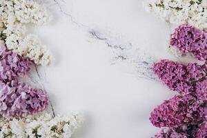 Floral pattern of a branch of lilac on a trendy marble background. Top view. Flat lay. Spring concept. Copy space photo
