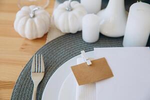 Thanksgiving table setting, tableware and decorations. Blank white postcard on table mockup. photo