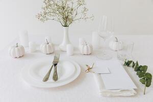 Thanksgiving table setting, tableware and decorations. Blank white postcard on table mockup. photo