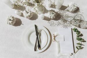 Thanksgiving table setting, tableware and decorations. Blank white postcard on table mockup, top view photo