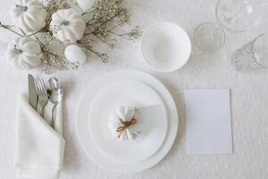 Thanksgiving table setting, tableware and decorations. Blank white postcard on table mockup, top view photo