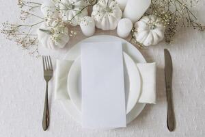 Thanksgiving table setting, tableware and decorations. Blank white postcard on table mockup, top view photo