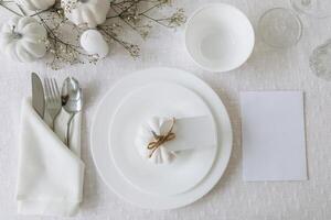 Thanksgiving table setting, tableware and decorations. Blank white postcard on table mockup, top view photo