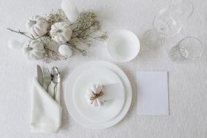 Thanksgiving table setting, tableware and decorations. Blank white postcard on table mockup, top view photo