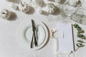 Thanksgiving table setting, tableware and decorations. Blank white postcard on table mockup, top view photo