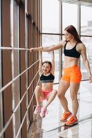 The daughter holds on to the mother's strong hand in the gym during training photo