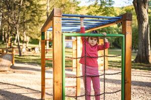 Active cute little girl on the playground photo