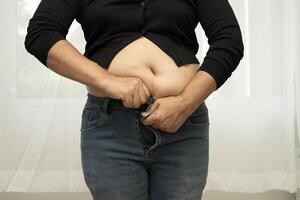 Asian woman show fat belly big size overweight and obesity isolated on white background with clipping path. photo