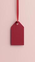 Rectangular red blank paper tag label price tag with hanging satin rope isolated pink photo