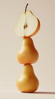 A stack of pear slice fruit balancing on top with solid background photo