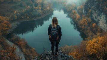 Woman standing in cliff looking to mountain view and valley autumn landscape nature environment photo