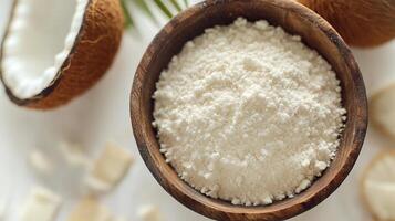 Coconut flour on brown wooden bowl and some Coconut slice for baking, gluten free copy space photo