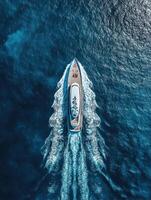 Luxury yacht cruising through sparkling blue waters in mid-afternoon photo
