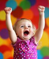 Cheering toddler with raised arms expresses joy against colorful background photo