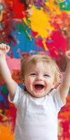 Joyful toddler with arms up, celebrating in a colorful setting photo