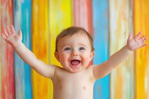 Cheerful toddler celebrating with arms raised against colorful background photo