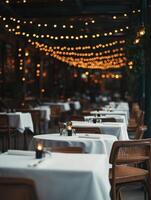 Cozy restaurant ambiance with empty tables and warm string lights at dusk photo