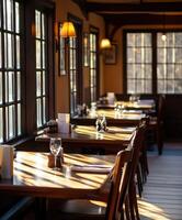 Cozy empty restaurant with sunlit wooden tables in a rustic setting photo