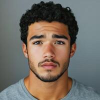 Athletic man with a confident expression posing against a gray background photo
