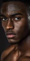 Athletic man poses confidently against a dark background in a close-up shot photo