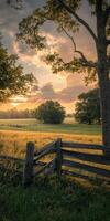 Golden sunset over a tranquil countryside field with wooden fence photo