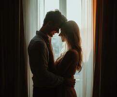 Silhouette of a couple sharing a tender moment by a sunlit window photo