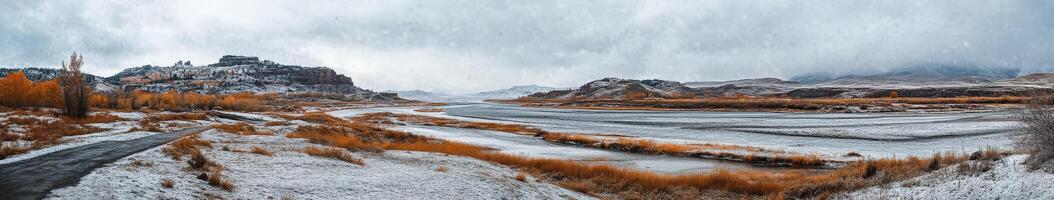 Majestic river valley with autumn colors and snow under grey skies photo