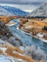 Majestic river valley surrounded by snowy mountains in winter photo