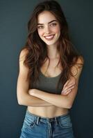 Young woman smiling with crossed arms against a plain background photo