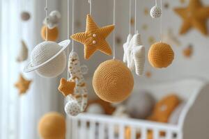 Baby mobile hanging over crib with knitted planets and stars in nursery photo